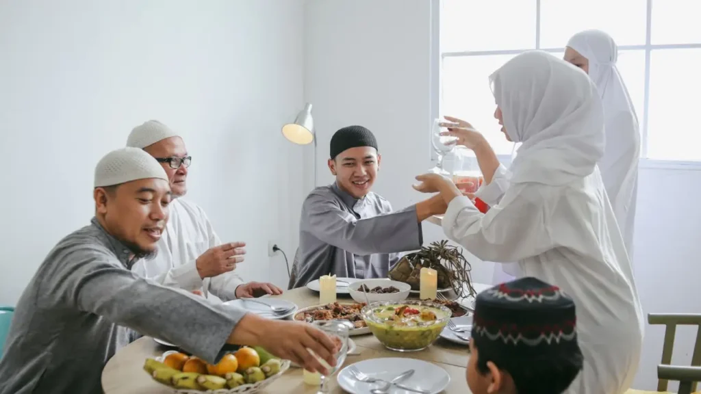 A Muslim family gathered around a dining table sharing a festive meal during Eid, reflecting India's traditions of togetherness, hospitality, and cultural diversity.