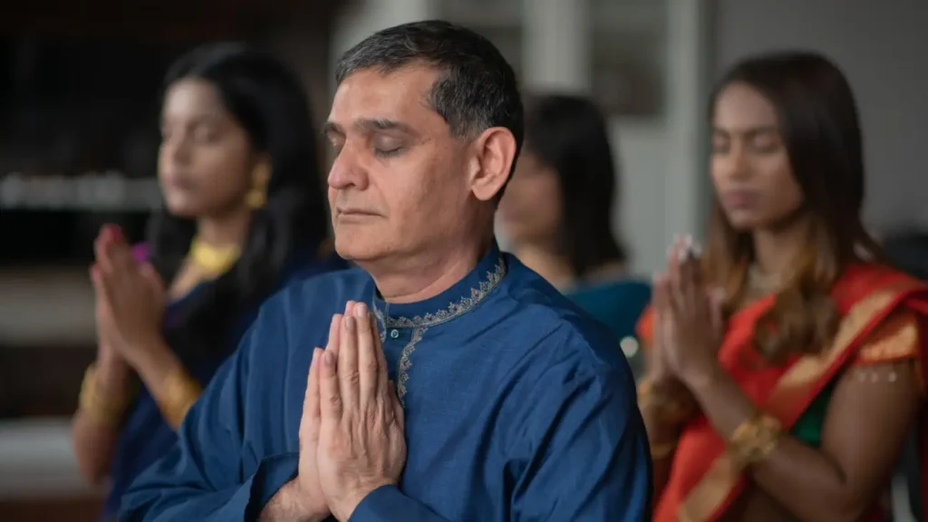 People dressed in traditional Indian attire offering prayers with folded hands, reflecting India's spirituality, religious traditions, and cultural harmony.